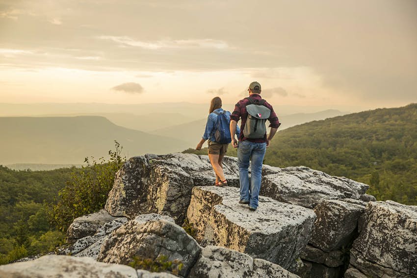 Un hombre y una mujer caminan sobre rocas en Virginia Occidental